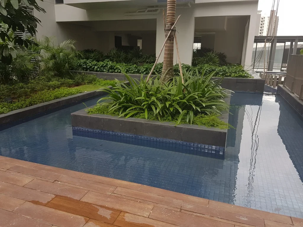 Landscaped pool with dark stone coping and blue tiled water feature